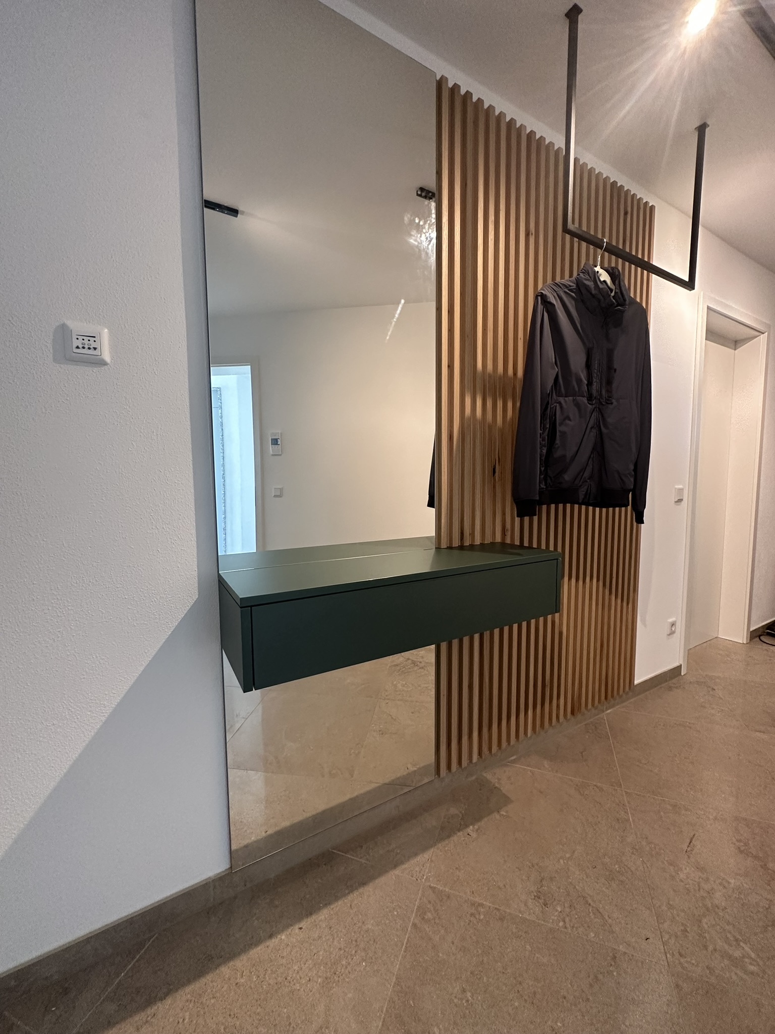 Moderner Innenausbau mit Spiegel, Holzlamellen und Hängeschrank
